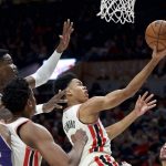 Portland Trail Blazers guard Anfernee Simons, right, shoots in front of Phoenix Suns center Deandre Ayton during the first half of an NBA basketball game in Portland, Ore., Monday, Dec. 30, 2019. (AP Photo/Craig Mitchelldyer)