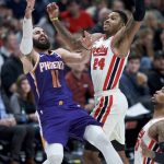 Phoenix Suns guard Ricky Rubio, left, shoots over Portland Trail Blazers guard Kent Bazemore during the second half of an NBA basketball game in Portland, Ore., Monday, Dec. 30, 2019. (AP Photo/Craig Mitchelldyer)
