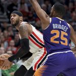 Portland Trail Blazers forward Carmelo Anthony, left, drives to the basket around Phoenix Suns forward Mikal Bridges during the second half of an NBA basketball game in Portland, Ore., Monday, Dec. 30, 2019. The Suns won 122-116. (AP Photo/Craig Mitchelldyer)