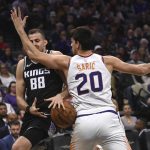 Sacramento Kings forward Nemanja Bjelica, left, loses the ball as he is defended by Phoenix Suns forward Dario Saric, right, during the first quarter of an NBA basketball game in Sacramento, Calif., Saturday, Dec. 28, 2019. (AP Photo/Hector Amezcua)