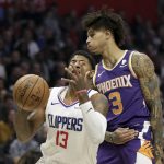 Los Angeles Clippers forward Paul George, left, is fouled by Phoenix Suns forward Kelly Oubre Jr. during the first half of an NBA basketball game in Los Angeles, Tuesday, Dec. 17, 2019. (AP Photo/Chris Carlson)