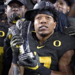 Oregon running back CJ Verdell holds the MVP trophy after Oregon defeated Utah 37-15 in an NCAA college football game for the Pac-12 Conference championship in Santa Clara, Calif., Friday, Dec. 6, 2018. (AP Photo/Tony Avelar)