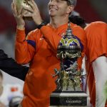 Clemson coach Dabo Swinney smiles while holding the trophy after Clemson defeated Ohio State 29-23 in the Fiesta Bowl NCAA college football playoff semifinal Saturday, Dec. 28, 2019, in Glendale, Ariz. (AP Photo/Rick Scuteri)