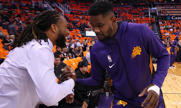 Deandre Ayton #22 of the Phoenix Suns greets Arizona Cardinals wide receiver Larry Fitzgerald befor...