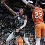 San Antonio Spurs' Dejounte Murray (5) shoots against Phoenix Suns' Deandre Ayton during the first half of an NBA basketball game, Friday, Jan. 24, 2020, in San Antonio. (AP Photo/Darren Abate)
