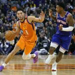 Phoenix Suns guard Devin Booker (1) drives on New York Knicks guard Elfrid Payton during the second half of an NBA basketball game Friday, Jan. 3, 2020, in Phoenix. The Suns defeated the Knicks 120-112. (AP Photo/Rick Scuteri)