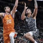 San Antonio Spurs' Trey Lyles (41) shoots against Phoenix Suns' Dario Saric during the first half of an NBA basketball game, Friday, Jan. 24, 2020, in San Antonio. (AP Photo/Darren Abate)