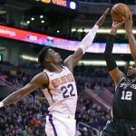 San Antonio Spurs center LaMarcus Aldridge (12) shoots over Phoenix Suns center Deandre Ayton during the first half of an NBA basketball game Monday, Jan. 20, 2020, in Phoenix. (AP Photo/Rick Scuteri)