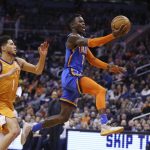 Oklahoma City Thunder guard Dennis Schroeder (17) drives past Phoenix Suns guard Devin Booker (1) during the first half of an NBA basketball game Friday, Jan. 31, 2020, in Phoenix. (AP Photo/Ross D. Franklin)