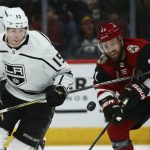 Los Angeles Kings defenseman Ben Hutton (15) and Arizona Coyotes center Derek Stepan (21) battle for the puck during the first period of an NHL hockey game Thursday, Jan. 30, 2020, in Glendale, Ariz. (AP Photo/Ross D. Franklin)