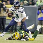 Seattle Seahawks' Russell Wilson runs past Green Bay Packers' Kenny Clark for a first down during the first half of an NFL divisional playoff football game Sunday, Jan. 12, 2020, in Green Bay, Wis. (AP Photo/Mike Roemer)
