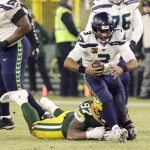 Seattle Seahawks' Russell Wilson gets away from Green Bay Packers' Kenny Clark during the first half of an NFL divisional playoff football game Sunday, Jan. 12, 2020, in Green Bay, Wis. (AP Photo/Darron Cummings)