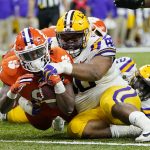 Clemson running back Travis Etienne scores past LSU defensive lineman Rashard Lawrence during the second half of a NCAA College Football Playoff national championship game Monday, Jan. 13, 2020, in New Orleans. (AP Photo/David J. Phillip)