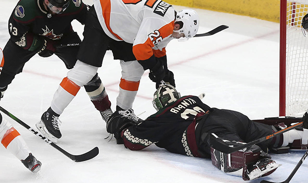 Arizona Coyotes goalie Antti Raanta (32) falls on the puck as Philadelphia Flyers' James van Riemsd...