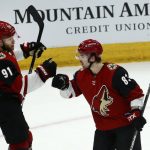 Arizona Coyotes left wing Taylor Hall (91) celebrates his goal against the San Jose Sharks with Coyotes right wing Conor Garland (83) during the second period of an NHL hockey game Tuesday, Jan. 14, 2020, in Glendale, Ariz. (AP Photo/Ross D. Franklin)