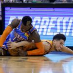 Phoenix Suns guard Devin Booker, right, dives after a loose ball with Oklahoma City Thunder guard Dennis Schroeder (17) during the second half of an NBA basketball game Friday, Jan. 31, 2020, in Phoenix. The Thunder won 111-107. (AP Photo/Ross D. Franklin)