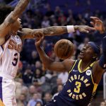 Indiana Pacers guard Aaron Holiday, right, loses the ball as Phoenix Suns forward Kelly Oubre Jr. defends during the first half of an NBA basketball game, Wednesday, Jan. 22, 2020, in Phoenix. (AP Photo/Matt York)
