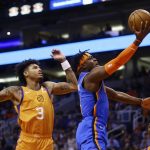 Oklahoma City Thunder guard Luguentz Dort, right, drives past Phoenix Suns forward Kelly Oubre Jr. (3) to score during the first half of an NBA basketball game Friday, Jan. 31, 2020, in Phoenix. (AP Photo/Ross D. Franklin)