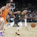 San Antonio Spurs' Dejounte Murray (5) and Phoenix Suns' Devin Booker chase the ball during the first half of an NBA basketball game, Friday, Jan. 24, 2020, in San Antonio. (AP Photo/Darren Abate)