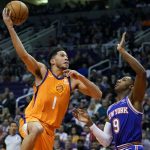 Phoenix Suns guard Devin Booker (1) shoots over New York Knicks guard RJ Barrett during the second half of an NBA basketball game Friday, Jan. 3, 2020, in Phoenix. The Suns won 120-112. (AP Photo/Rick Scuteri)
