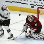 Arizona Coyotes goaltender Adin Hill (31) makes a save on a shot as San Jose Sharks right wing Barclay Goodrow (23) looks on during the second period of an NHL hockey game Tuesday, Jan. 14, 2020, in Glendale, Ariz. (AP Photo/Ross D. Franklin)
