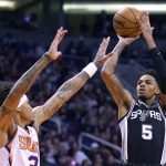 San Antonio Spurs guard Dejounte Murray (5) shoots over Phoenix Suns forward Kelly Oubre Jr. during the first half of an NBA basketball game Monday, Jan. 20, 2020, in Phoenix. (AP Photo/Rick Scuteri)