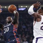 Phoenix Suns center Deandre Ayton (22) keeps his distance as New York Knicks forward Julius Randle (30) takes a shot during the first quarter of an NBA basketball game in New York, Thursday, Jan. 16, 2020. (AP Photo/Kathy Willens)