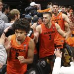 Oregon State's Ethan Thompson (5), Tres Tinkle (3) and Roman Silva celebrate their 82-65 win over Arizona with fans after an NCAA college basketball game in Corvallis, Ore., Sunday, Jan. 12, 2020. (AP Photo/Chris Pietsch)