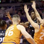 Orlando Magic's Wes Iwundu, back right, passes the ball after running into Phoenix Suns' Dario Saric (20) during the first half of an NBA basketball game Friday, Jan. 10, 2020, in Phoenix. (AP Photo/Darryl Webb)