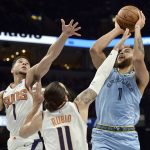 Memphis Grizzlies forward Kyle Anderson, right, shoots against Phoenix Suns guards Devin Booker, left, and guard Ricky Rubio (11) in the first half of an NBA basketball game Sunday, Jan. 26, 2020, in Memphis, Tenn. (AP Photo/Brandon Dill)