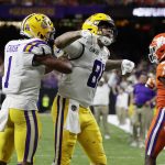 LSU tight end Thaddeus Moss, center, celebrates after scoring with wide receiver Ja'Marr Chase during the second half of a NCAA College Football Playoff national championship game against Clemson, Monday, Jan. 13, 2020, in New Orleans. (AP Photo/Sue Ogrocki)