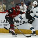 Arizona Coyotes defenseman Alex Goligoski (33) shoves San Jose Sharks defenseman Erik Karlsson (65) away from the puck during the third period of an NHL hockey game Tuesday, Jan. 14, 2020, in Glendale, Ariz. The Coyotes defeated the Sharks 6-3. (AP Photo/Ross D. Franklin)