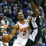 Phoenix Suns forward Elie Okobo (2) drives on San Antonio Spurs guard Lonnie Walker IV during the second half of an NBA basketball game Monday, Jan. 20, 2020, in Phoenix. San Antonio won 120-118. (AP Photo/Rick Scuteri)
