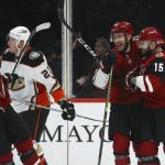 Arizona Coyotes center Brad Richardson (15) celebrates his goal with defenseman Jordan Oesterle, second from right, and right wing Christian Fischer (36) as Anaheim Ducks left wing Nicolas Deslauriers (20) skates past during the third period of an NHL hockey game Thursday, Jan. 2, 2020, in Glendale, Ariz. The Coyotes won 4-2. (AP Photo/Ross D. Franklin)