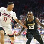 Colorado guard McKinley Wright IV (25) shields the ball from Arizona forward Ira Lee during the first half of an NCAA college basketball game Saturday, Jan. 18, 2020, in Tucson, Ariz. (AP Photo/Rick Scuteri)