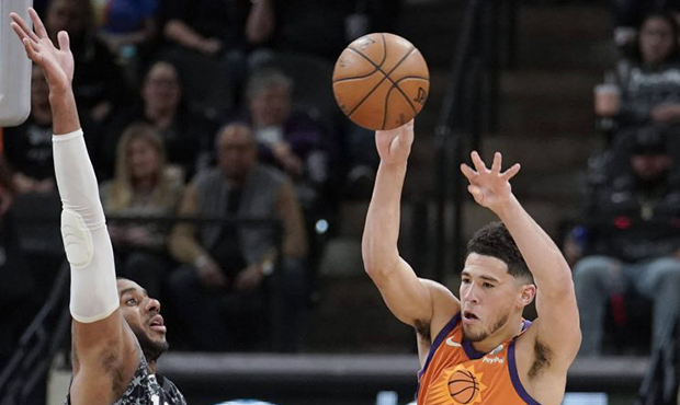Phoenix Suns' Devin Booker (1) passes the ball as he is defended by San Antonio Spurs' LaMarcus Ald...