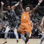 Phoenix Suns' Kelly Oubre, Jr. (3) reacts as the ball is knocked away by San Antonio Spurs' Dejounte Murray during the first half of an NBA basketball game, Friday, Jan. 24, 2020, in San Antonio. (AP Photo/Darren Abate)
