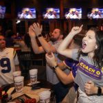 Montana Ankner, right, cheers on LSU while watching them take on Clemson in the NCAA College Football Playoff championship game at Walk-On's Sports Bistreaux, in Baton Rouge, La., Monday, Jan. 13, 2020. (AP Photo/Brett Duke)