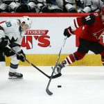 Arizona Coyotes left wing Taylor Hall (91) skates past the puck as San Jose Sharks left wing Marcus Sorensen (20) moves in to take control of the puck during the third period of an NHL hockey game Tuesday, Jan. 14, 2020, in Glendale, Ariz. The Coyotes defeated the Sharks 6-3. (AP Photo/Ross D. Franklin)