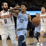 Memphis Grizzlies guard Ja Morant (12) drives ahead of Phoenix Suns guards Ricky Rubio (11) and Devin Booker (1) in the first half of an NBA basketball game Sunday, Jan. 26, 2020, in Memphis, Tenn. (AP Photo/Brandon Dill)