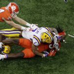 LSU safety Grant Delpit knocks the helmet off Clemson running back Travis Etienne during the first half of a NCAA College Football Playoff national championship game Monday, Jan. 13, 2020, in New Orleans. (AP Photo/Eric Gay)