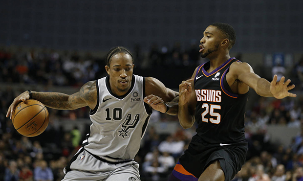 San Antonio Spurs' DeMar DeRozan carries the ball past Phoenix Suns' Mikal Bridges in the second ha...
