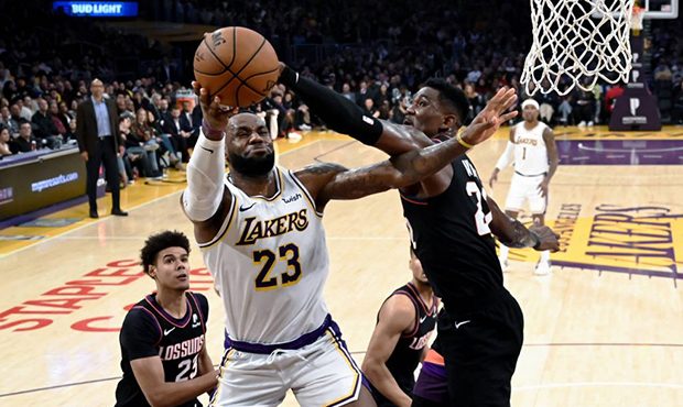 Los Angeles Lakers' LeBron James (23) goes up to basket under pressure from Phoenix Suns' Deandre A...