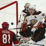 Anaheim Ducks defenseman Josh Manson (42) raises his stick to make contact with the puck in front of Arizona Coyotes right wing Phil Kessel (81) as Ducks goaltender John Gibson (36) looks on during the second period of an NHL hockey game Thursday, Jan. 2, 2020, in Glendale, Ariz. (AP Photo/Ross D. Franklin)