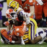 LSU safety Grant Delpit knocks the helmet off Clemson running back Travis Etienne during the first half of a NCAA College Football Playoff national championship game Monday, Jan. 13, 2020, in New Orleans. (AP Photo/Sue Ogrocki)