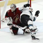 Arizona Coyotes goaltender Adin Hill, left, trips San Jose Sharks right wing Timo Meier, as Hill is called for a penalty on the play, during the third period of an NHL hockey game Tuesday, Jan. 14, 2020, in Glendale, Ariz. The Coyotes defeated the Sharks 6-3. (AP Photo/Ross D. Franklin)
