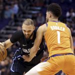 Orlando Magic's Evan Fournier (10) tries to drive around Phoenix Suns' Devin Booker (1) during the first half of an NBA basketball game Friday, Jan. 10, 2020, in Phoenix. (AP Photo/Darryl Webb)