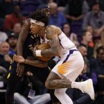 Phoenix Suns forward Kelly Oubre Jr., right, fouls Indiana Pacers guard Aaron Holiday as he drives to the basket during the first half of an NBA basketball game, Wednesday, Jan. 22, 2020, in Phoenix. (AP Photo/Matt York)