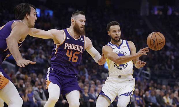 Golden State Warriors' Stephen Curry, right, passes the ball away from Phoenix Suns' Aron Baynes (4...