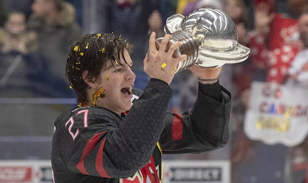 Canada's captain Barrett Hayton holds the trophy as he celebrates after defeating Russia in the gol...